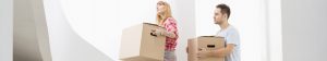 couple-carrying-cardboard-boxes-up-stairs-in-new-house